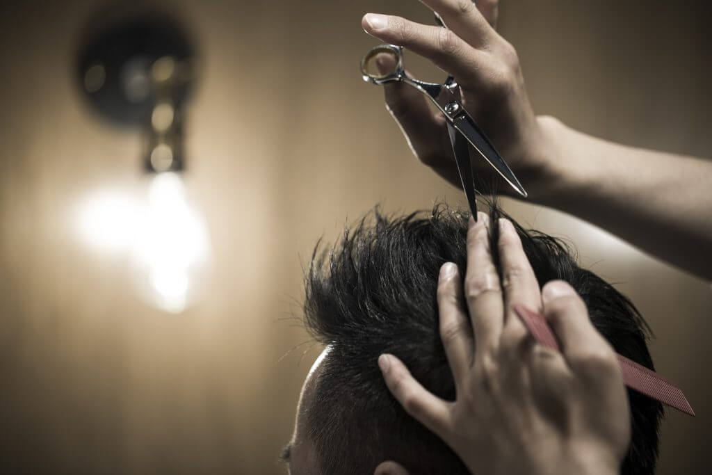 ハサミで髪をカットする美容師美容師の手