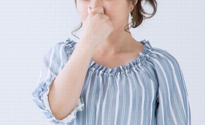 鼻を押さえる女性