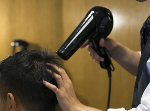 ドライヤーでくせ毛を乾かす理容師