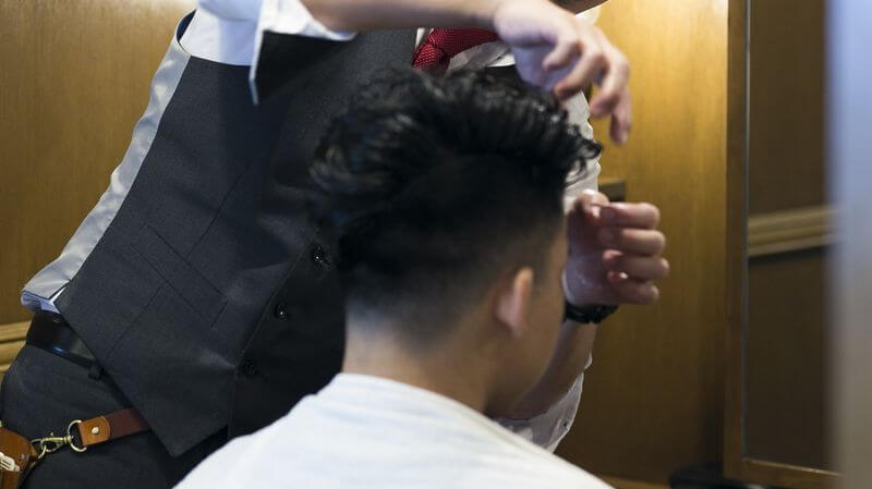 くせ毛のヘアセットをする理容師