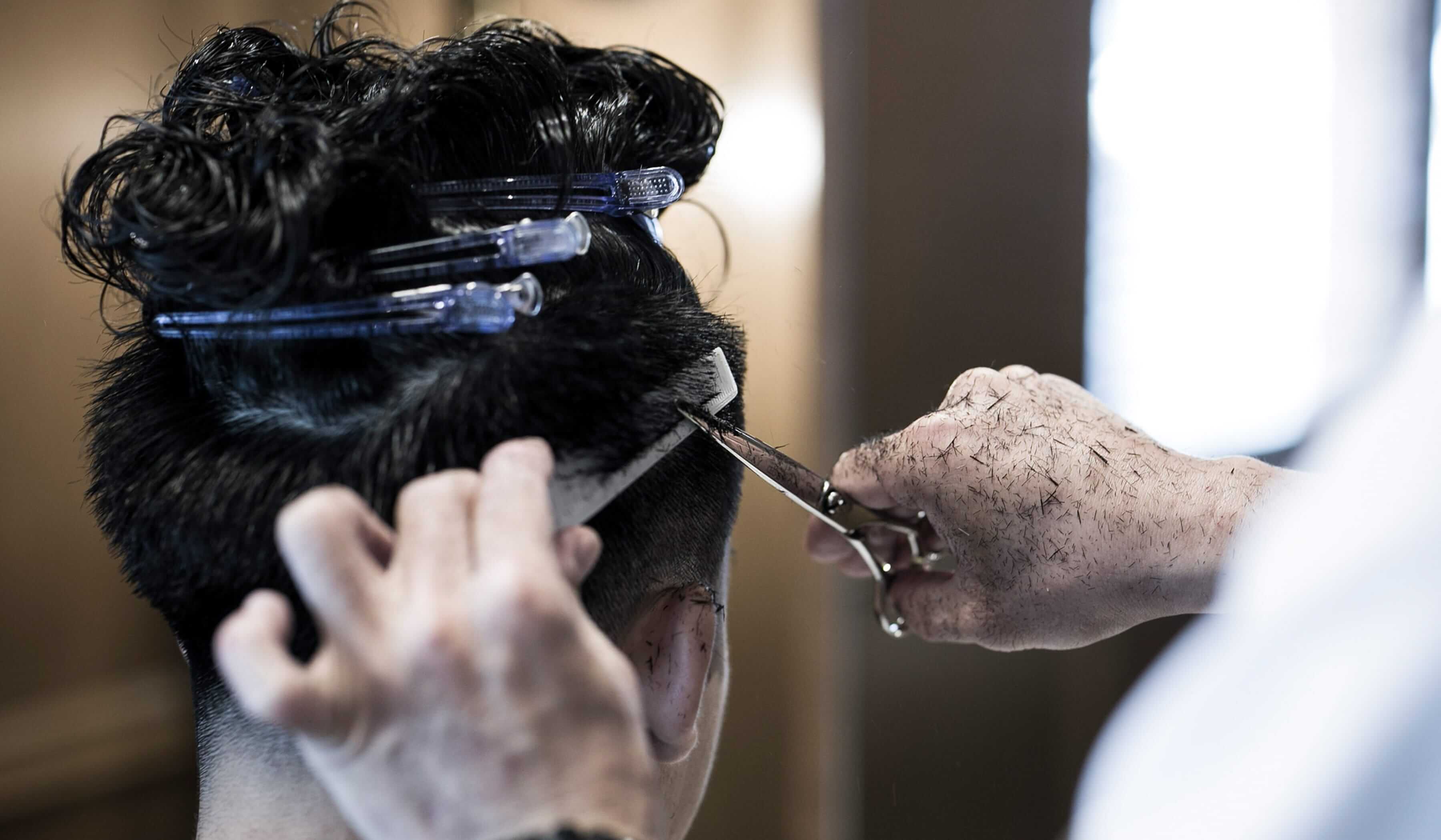 カットする理容師の手