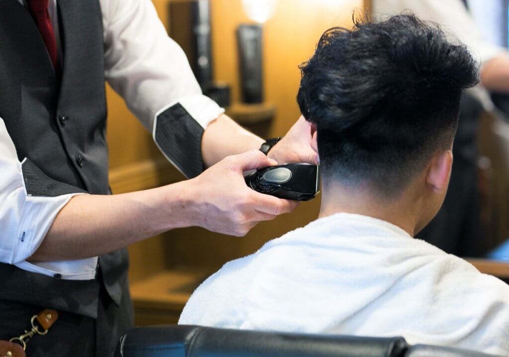 フェードカットする理容師の手